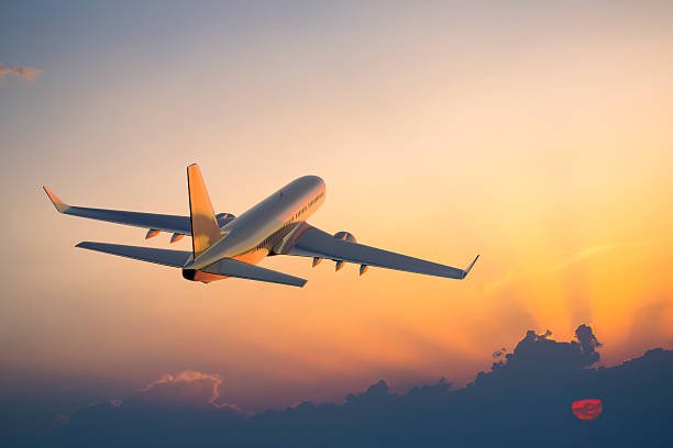 Passanger airplane flying above clouds in evening